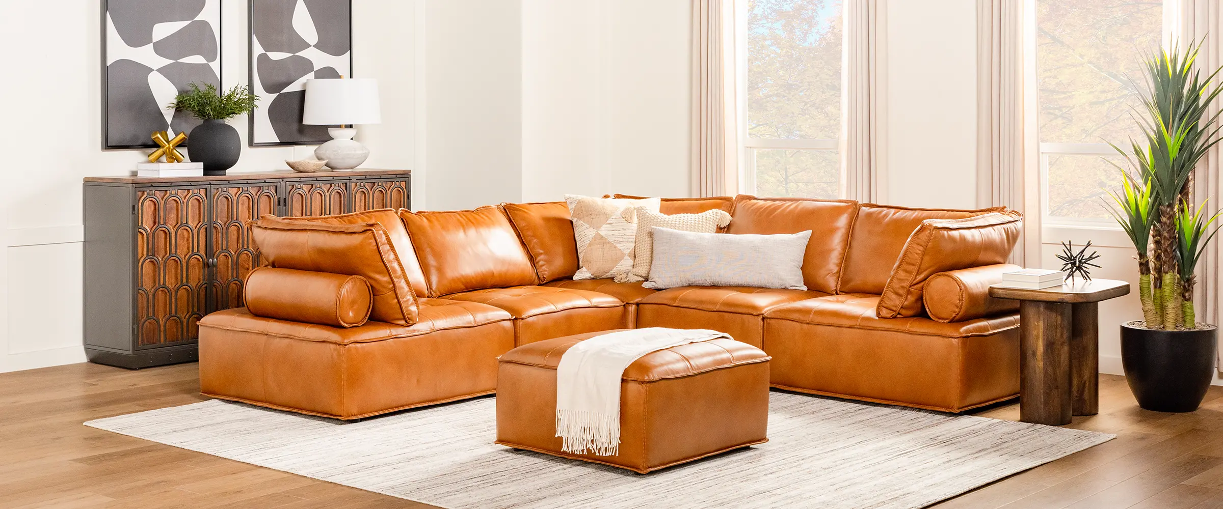 Modern, brown leather sectional with matching ottoman
