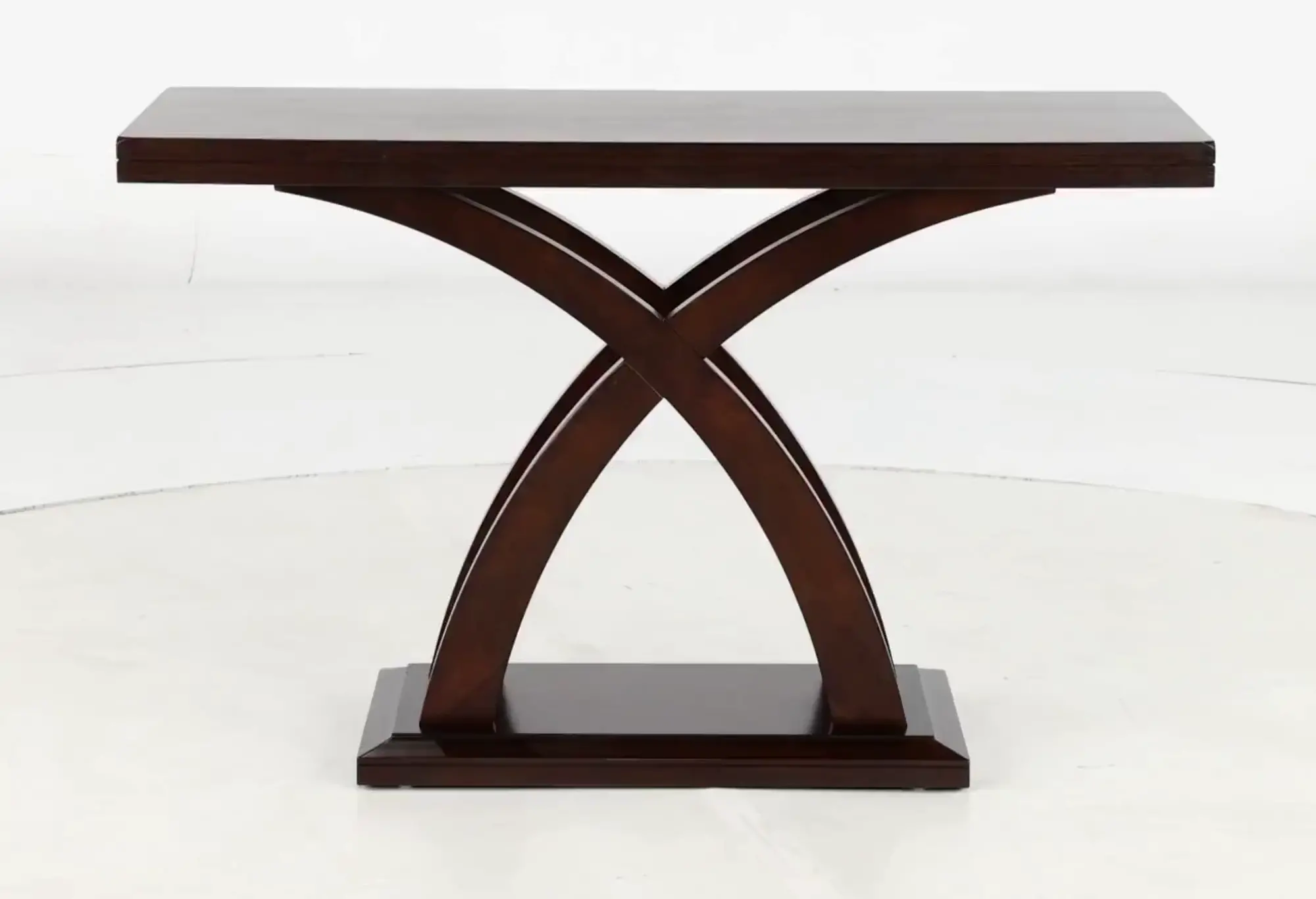 Side view of a dark wooden table with curved X-shaped legs and a wide base.