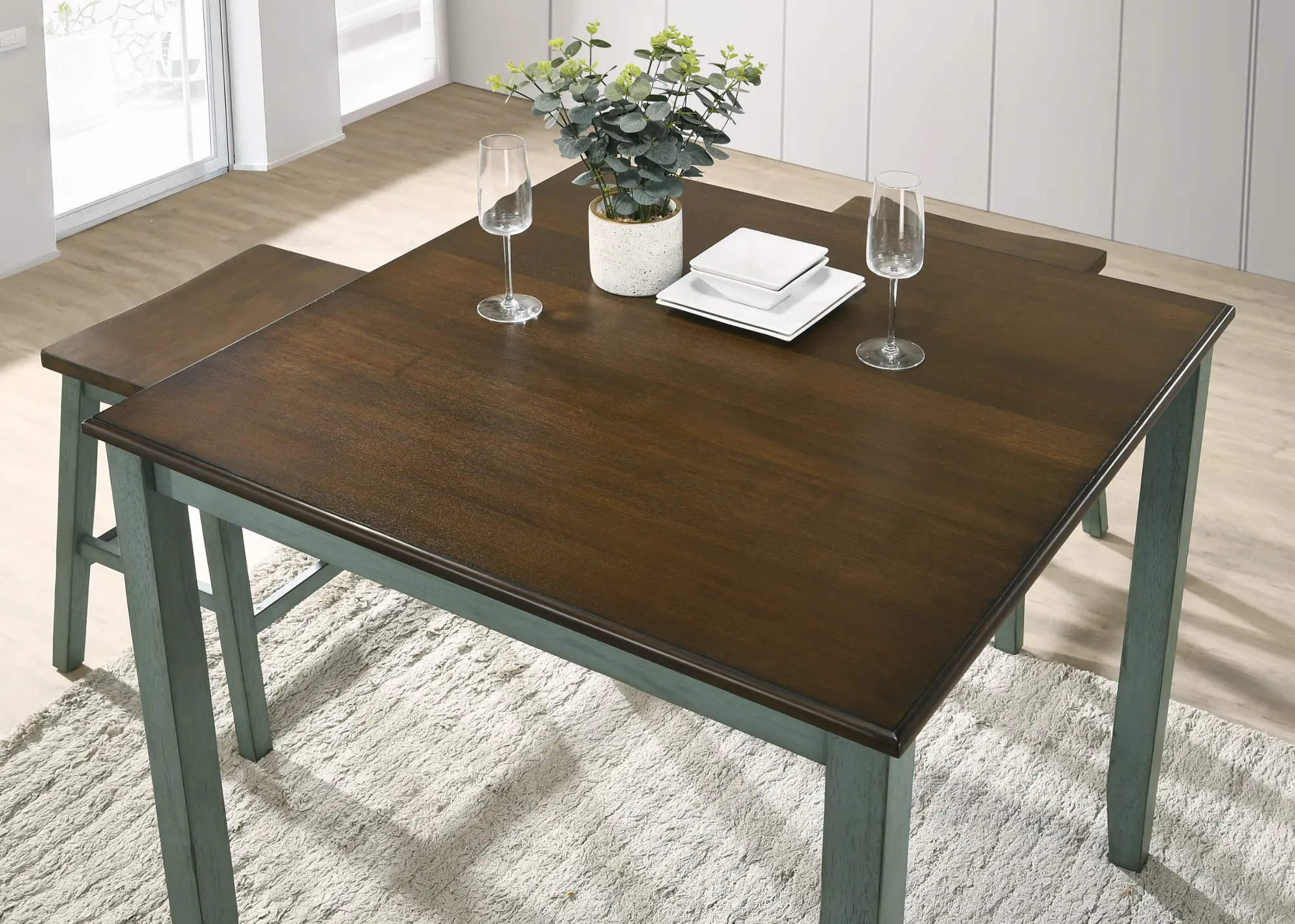 A wooden stool with a dark brown seat and a distressed blue-green painted frame, simple rustic design