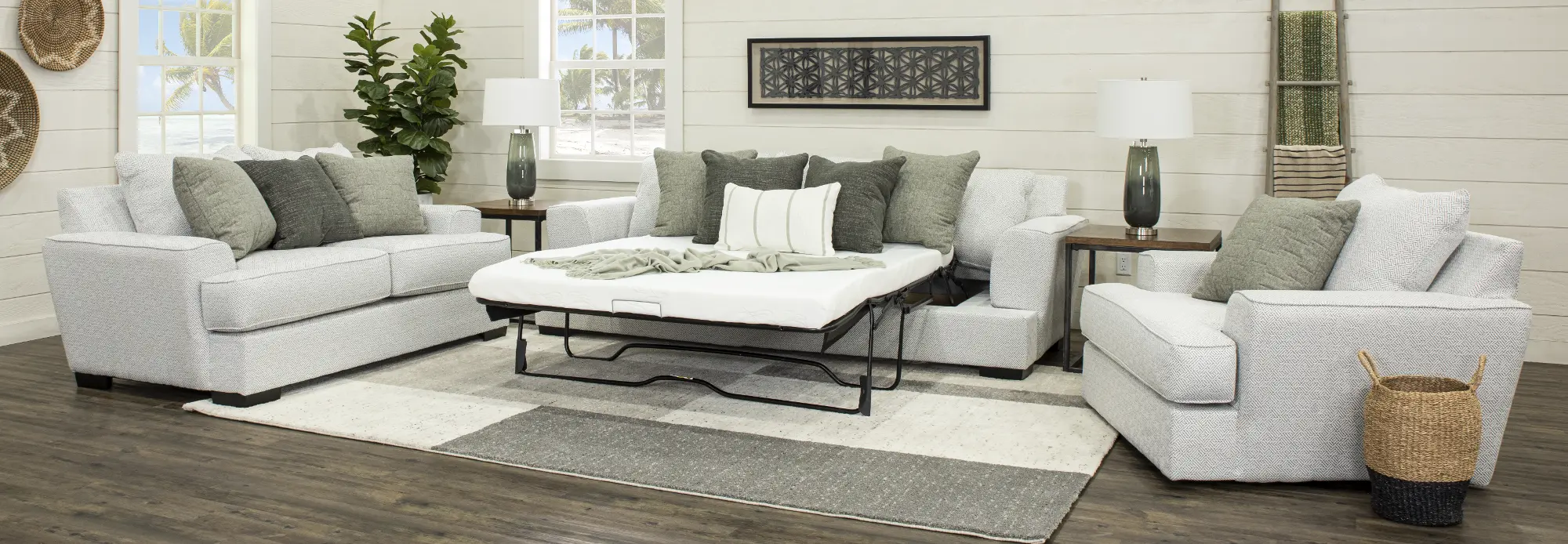 Corner view of a light gray patterned sofa with dark gray cushions