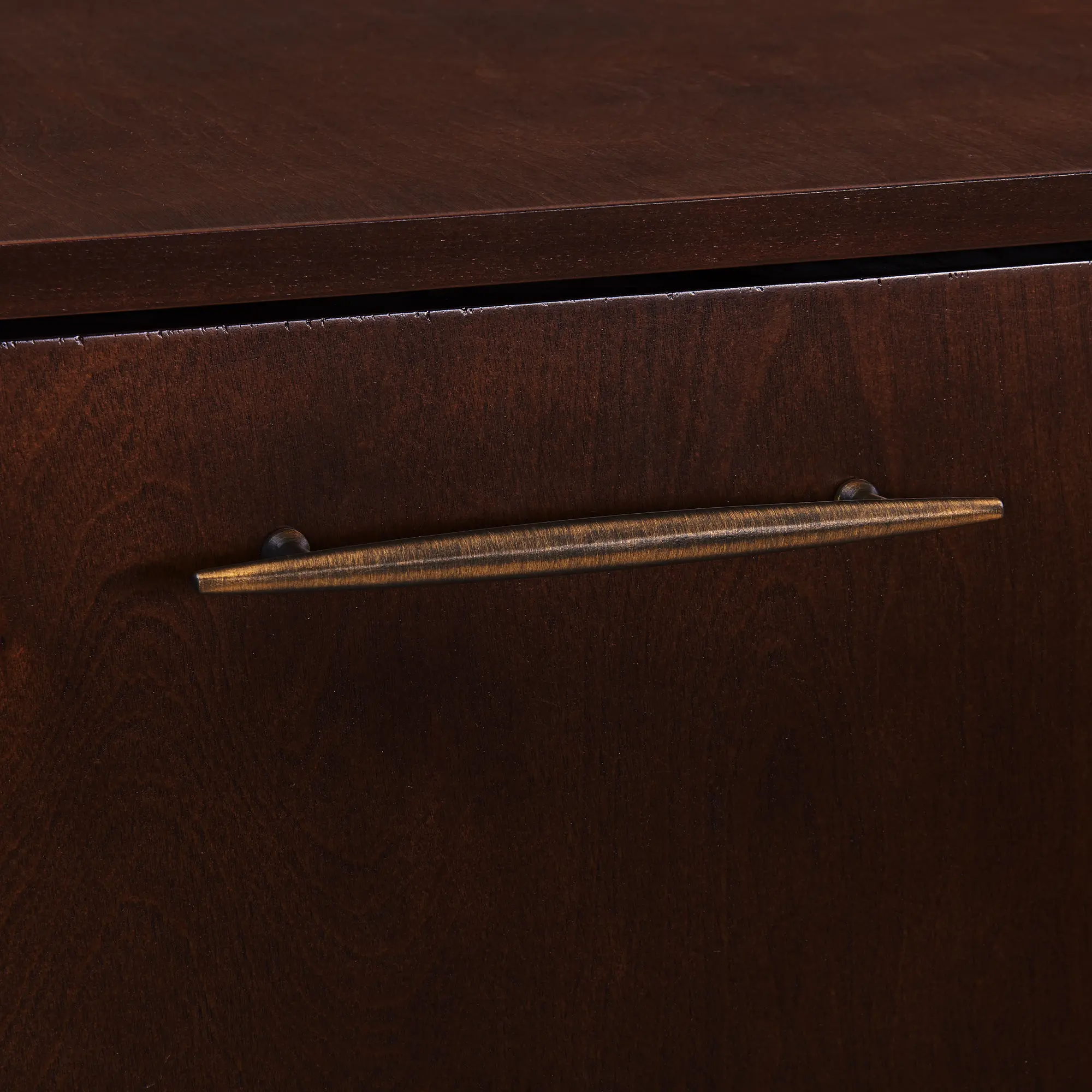 Close-up of wood veneer and drawer handle on the cabinet.