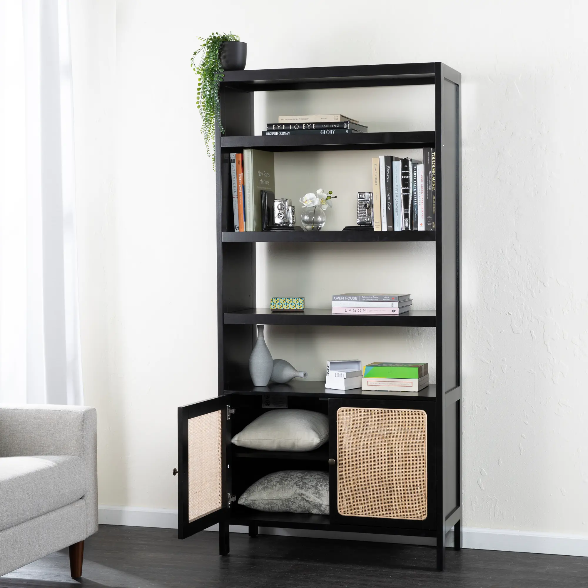 Close-up of the black shelving unit showing the top shelves and woven cabinet doors