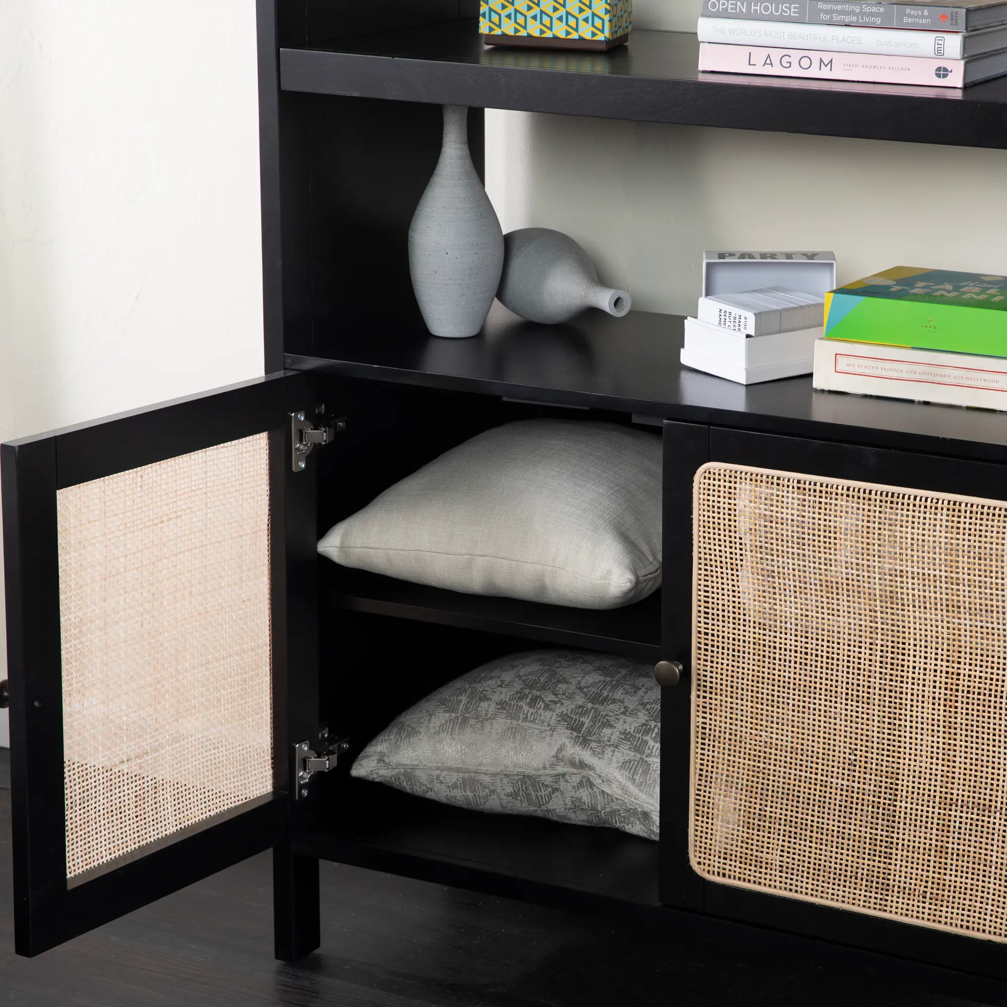 Open cabinet doors revealing shelves with cushions and decorative items