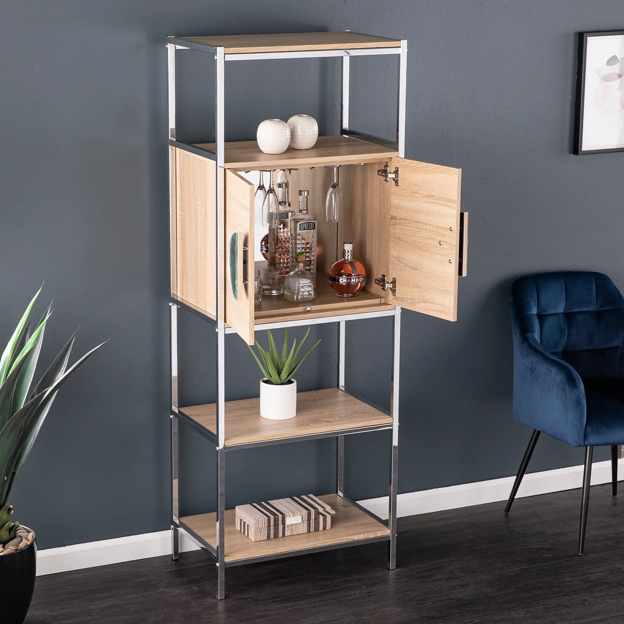 Open cabinet on a shelving unit revealing bottles and glassware hanging rack underneath, top decorations visible.