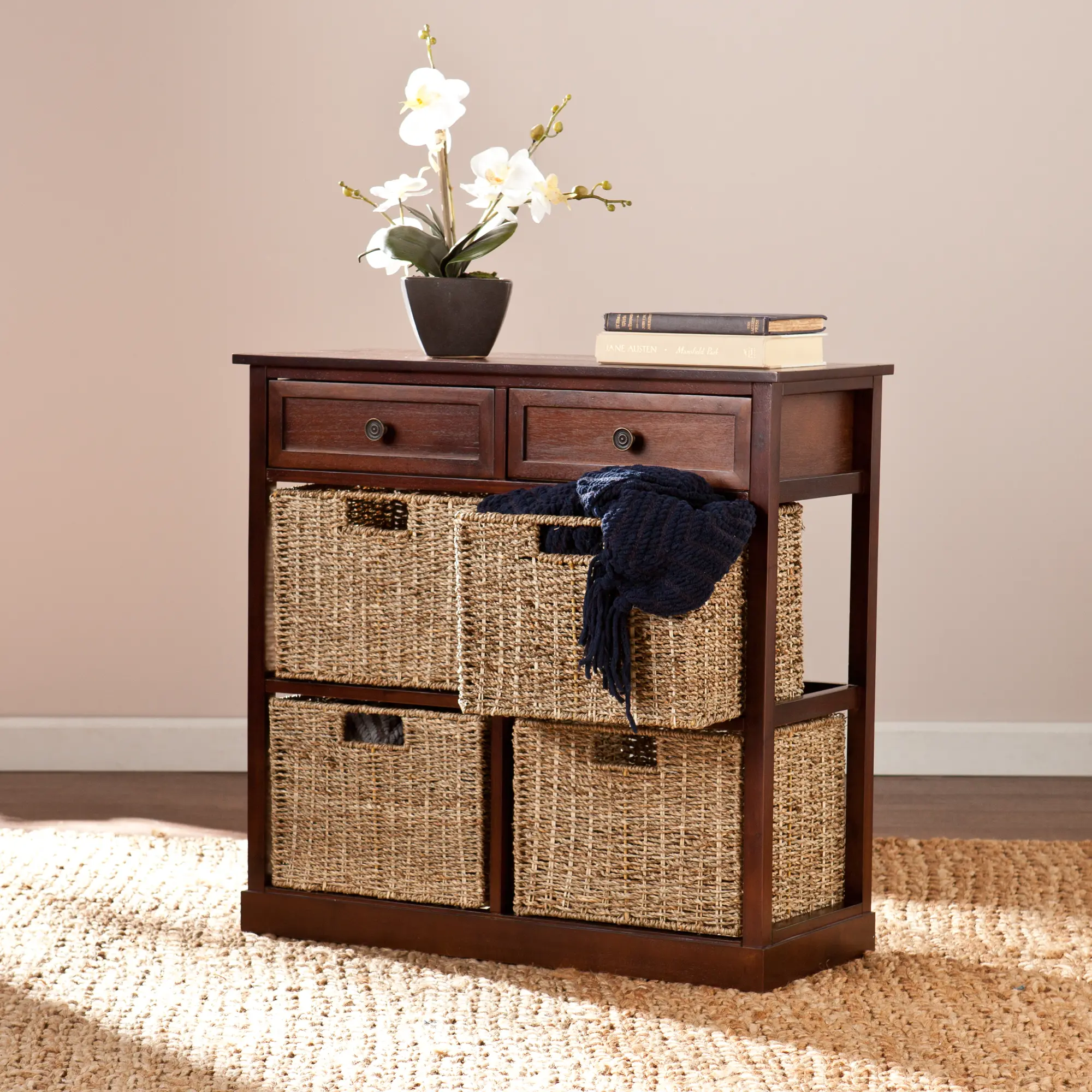 Close view of the dark wood console showing two top drawers and woven baskets, with a navy scarf draped over one basket.