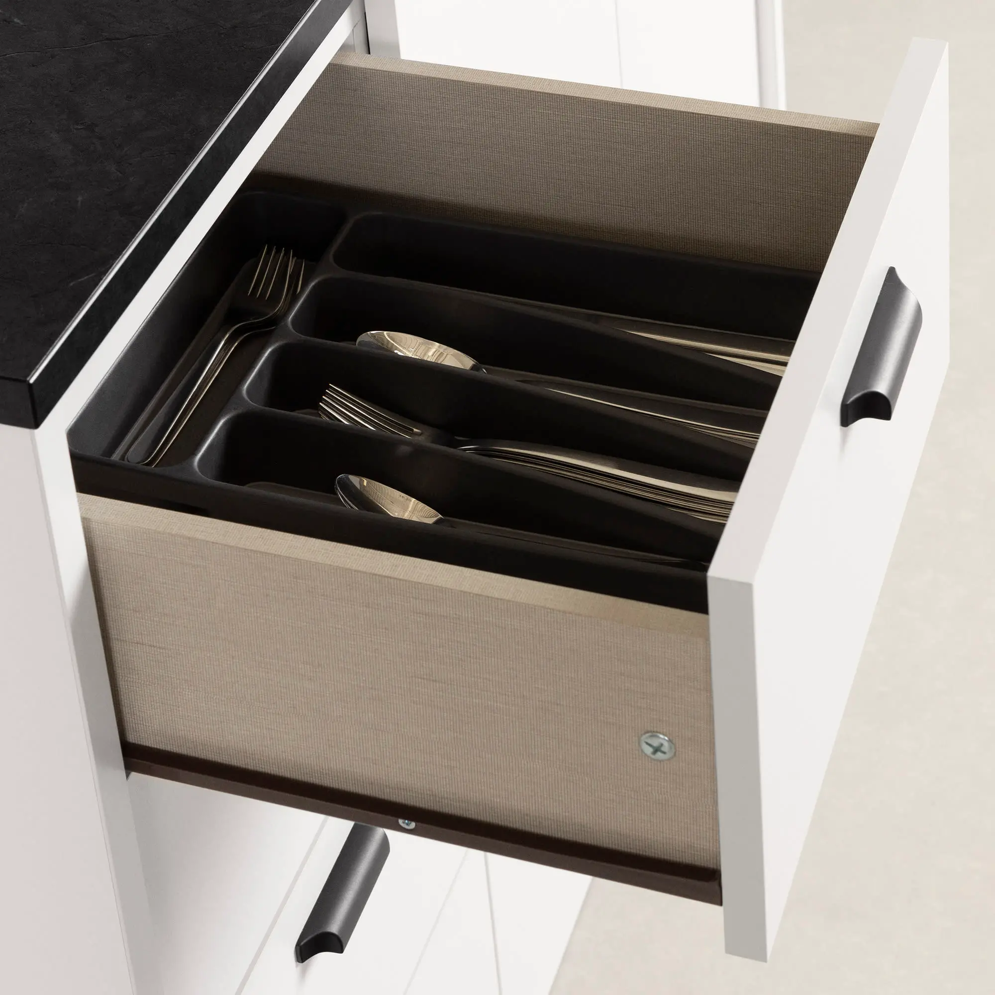 Black cabinet handle mounted on white cabinet door.
