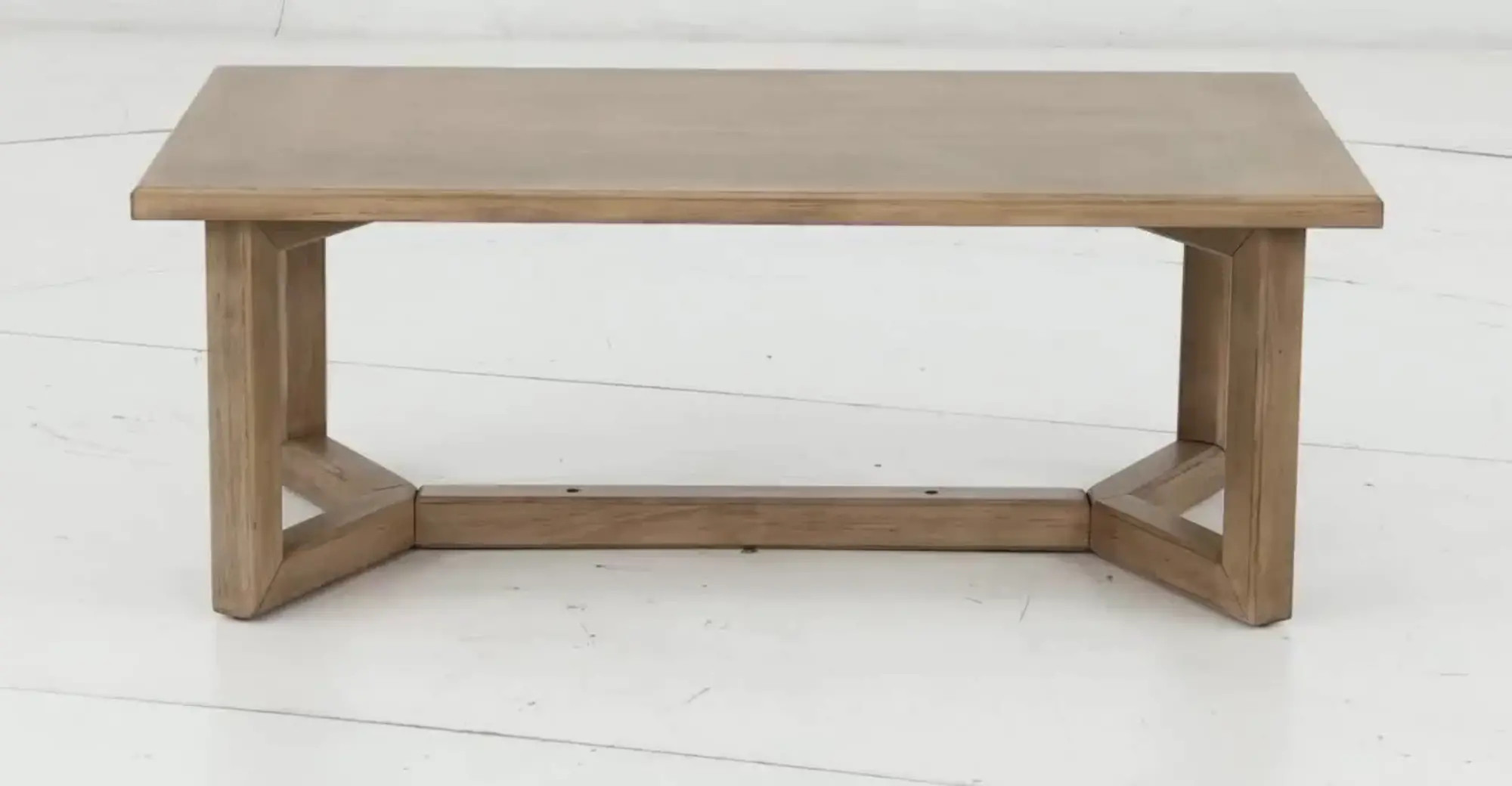Front view of a simple wooden coffee table with thick rectangular top and U-shaped legs connected by a base.